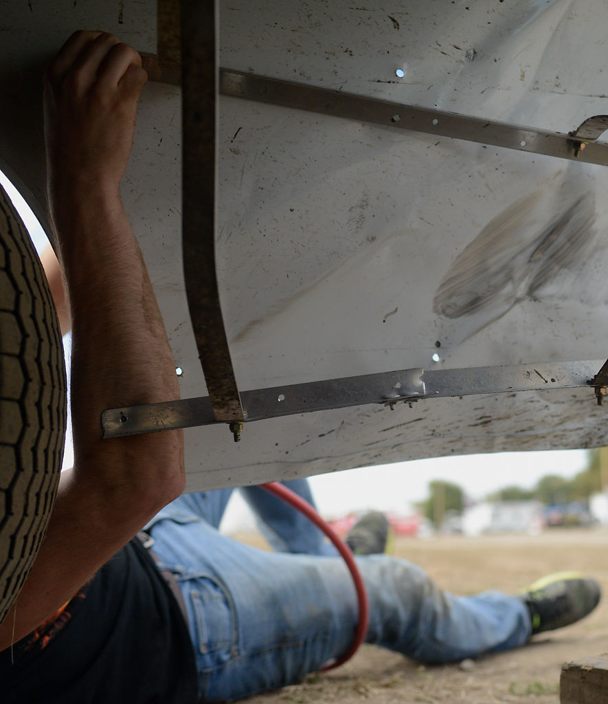 Louie Lovelace inspects some damage done to the sheet metal
